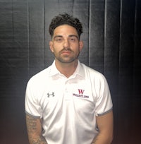 a man in a white polo posing for a photo